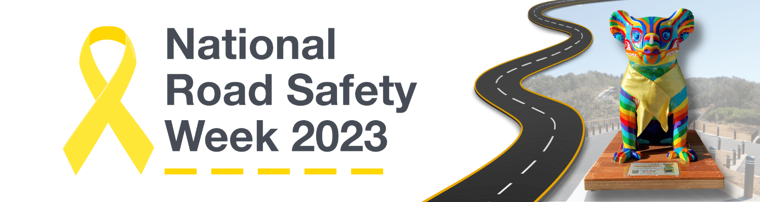 National Road Safety week 2023 with yellow ribbon symbol and a Hello Koala wearing a Yellow ribbon seperated by a curving road